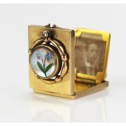 An Antique Forget-Me-Not Crystal Metamorphic Pendant Locket set with a rose cut diamond, in a precious yellow metal setting, the crystal swivelling to reveal an aperture and the locket opening to a spring loaded panel mounted with a photograph with the whole converting into a magnifier, KEE tested as 15ct, 26.5mm drop,  5.14g
