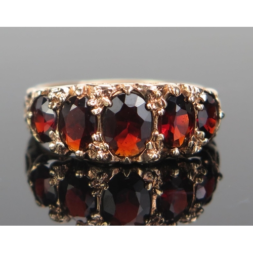 162 - A 9ct Gold and Garnet Five Stone Ring, 7x5.5mm central stone, hallmarked, size Q, 2.97g