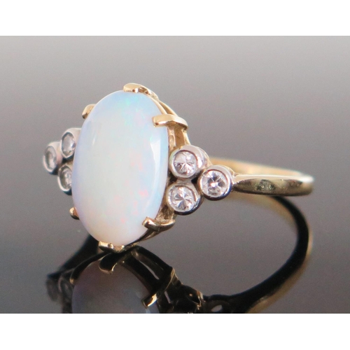 196 - An 18ct Gold, Opal and Diamond Ring, 12.5x8.5mm central stone flanked by three c, .2mm diamonds in r... 