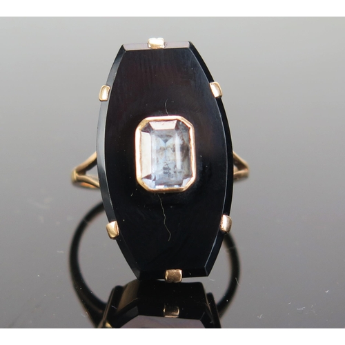 200 - A Gent's Coffin Shaped Ring mounted with a black onyx or glass panel and a foil backed pale blue eme... 