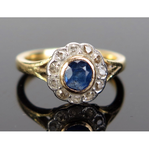 228 - A Sapphire and Diamond Cluster Ring in a precious yellow and white metal setting, size H.25, 3.17g. ... 