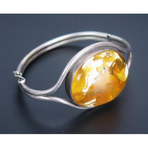 271 - An Amber Set Bangle in a precious white metal hinged setting, 38x32mm sample