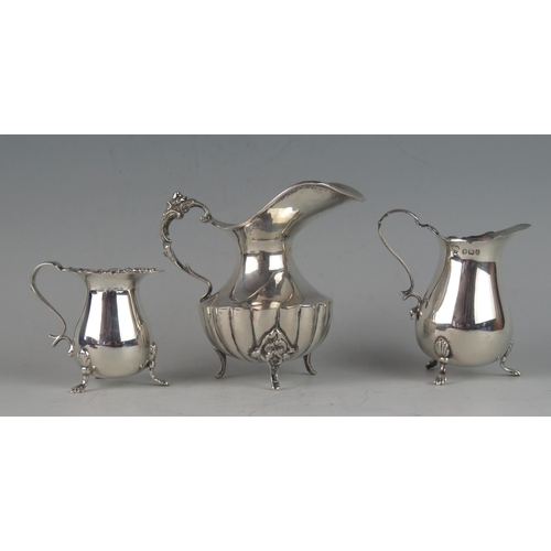 502 - A continental silver cream jug, stamped marks with flared spout, lobed body on three swept feet, 10c... 