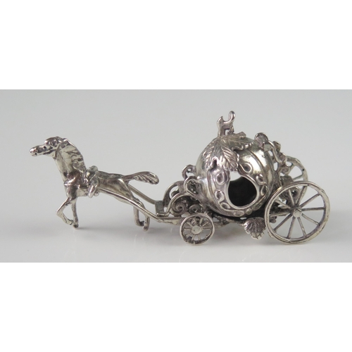 506 - A miniature silver model of a coach, unmarked, with melon-shaped coachworks drawn by a single horse,... 