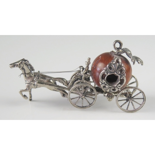 507 - A miniature silver model of a coach, unmarked, with nut coachworks drawn by a single horse, with dri... 