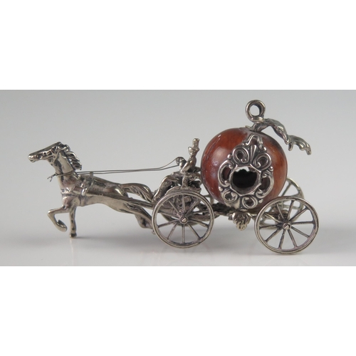 507 - A miniature silver model of a coach, unmarked, with nut coachworks drawn by a single horse, with dri... 