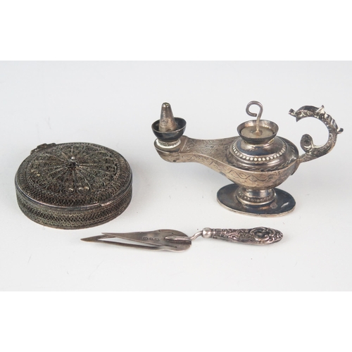 708 - A Middle Eastern silver miniature oil lamp, 8cm long, a silver filigree circular box with hinged lid... 