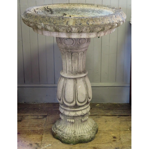 1361 - A reconstituted stone bird bath, the circular bath with moulded rim raised on a waisted and knopped ... 