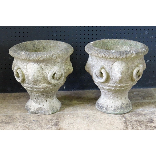 1362 - A pair of reconstituted stone garden urns, of campana form with lion mask decoration, on circular ba... 