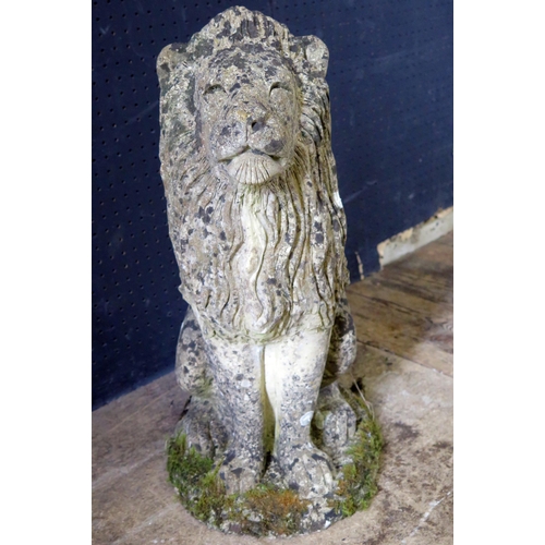 1363 - A reconstituted stone figure of a semi-recumbent lion, mounted on an oval base, 55cm high.