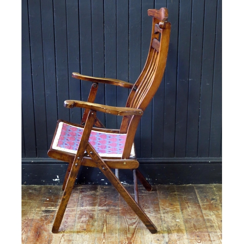 1422 - A stained beech folding elbow chair, with arched top rail and slat back, having a gross point wool w... 