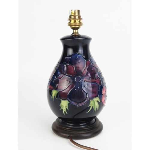 1004 - A Moorcroft pottery table amp of ovoid form with piped Anemone pattern decoration, mounted on a poli... 