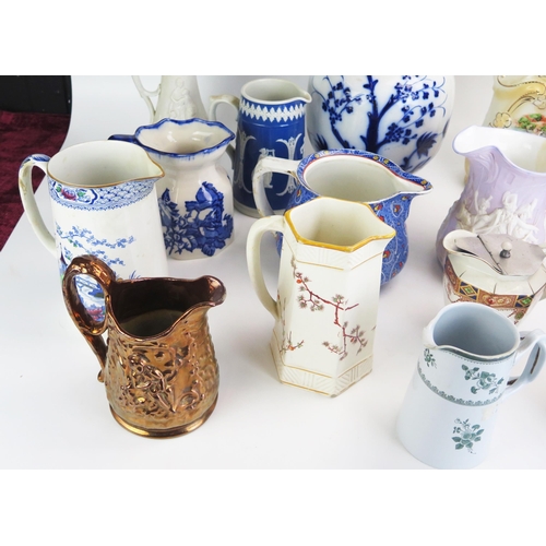 1026 - A collection of late Victorian and later pottery jugs, including moulded jugs, transfer print decora... 