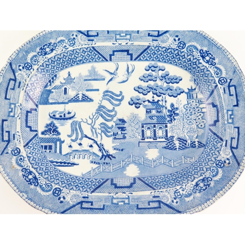 1052 - A 19th century Staffordshire pottery meat dish with blue and white Willow pattern transfer print dec... 