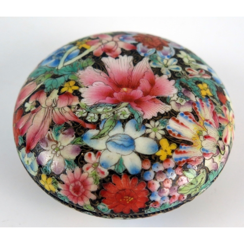 1112 - A Chinese famille rose small dish and cover, with all over flowerhead decoration, on a circular foot... 