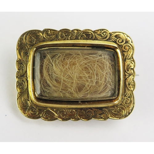 112 - A 19th Century Precious Yellow Metal Memorial Brooch with foliate scroll decorative border and centr... 