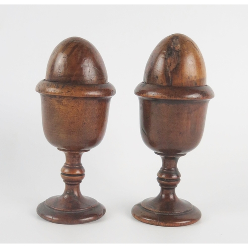 1238 - A pair of 189th century treen egg cups, together with treen eggs, 13cm high.