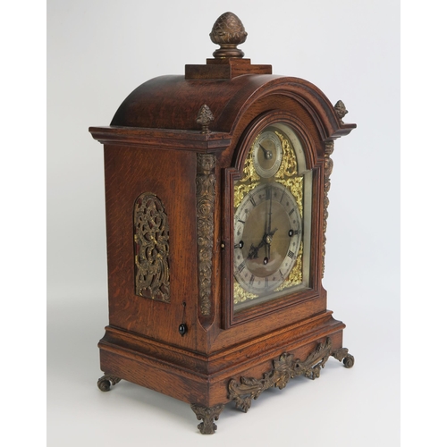 1287 - A late Victorian/Edwardian oak mantel clock, of arched outline, with brass arched dial, silvered cha... 