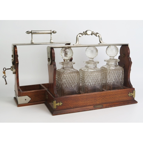 1289 - An Edwardian three decanter polished oak tantalus, with Betjemann's patent locking mechanism, with t... 