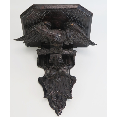 1290 - A carved hardwood wall bracket, the shelf supported by an eagle with outspread wings, overall height... 