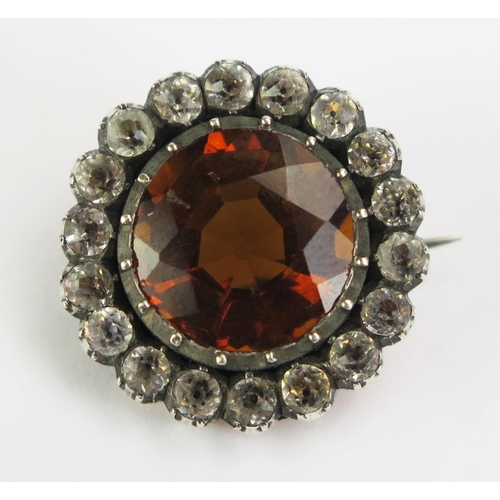 133 - An Antique Orange Stone and Paste Brooch in a yellow and white metal setting, 20mm diam. 6.48g gross