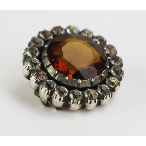 133 - An Antique Orange Stone and Paste Brooch in a yellow and white metal setting, 20mm diam. 6.48g gross