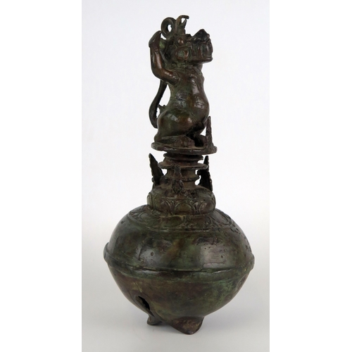 1352 - An Indonesian bronze temple bell, of globular outline, the handle in the form of a Makara, 25cm high... 