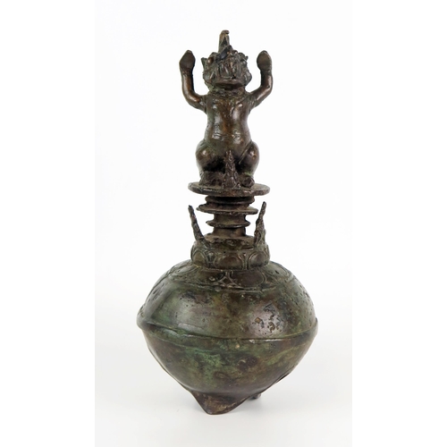 1352 - An Indonesian bronze temple bell, of globular outline, the handle in the form of a Makara, 25cm high... 