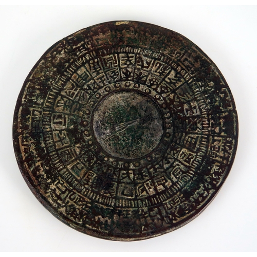 1356 - A Chinese bronze circular calendar disc, with banded characters, 11cm diameter.