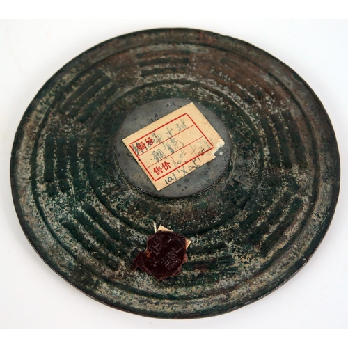 1356 - A Chinese bronze circular calendar disc, with banded characters, 11cm diameter.