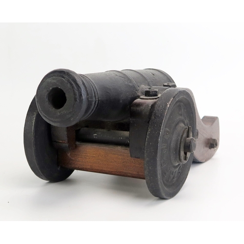 1379 - A cast iron and wood model of a cannon, with 22cm barrel, on a wood carriage with cast iron wheels o... 