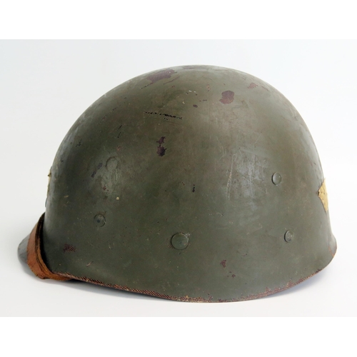 1384 - An American M1 pattern helmet liner with leather chin strap, bears paper label 'NATO' to the front.