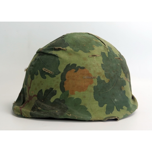 1385 - An American M1 pattern helmet with liner and camouflage cover, possibly Vietnam period.