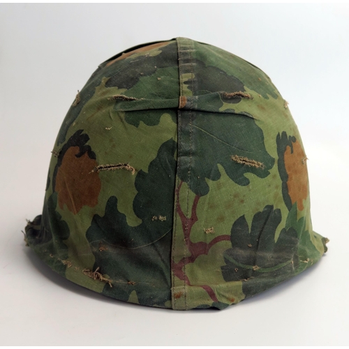 1385 - An American M1 pattern helmet with liner and camouflage cover, possibly Vietnam period.