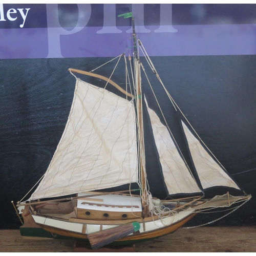 1390A - A model of a single masted yacht, the half painted hull of clinker construction, cabin, main sail an... 