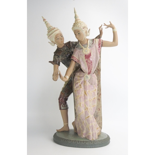 1492 - A large Lladro porcelain figure of two Siamese dancers, each in painted headdress, and on oval base,... 