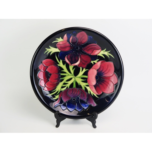 1506 - A Moorcroft pottery plate  'Anemone' pattern decoration, designed by W. Moorcroft, Circa 1988, 26cm ... 