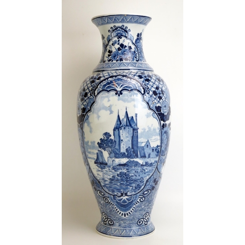 1539 - A large 20th century delft vase, with central cartouche decorated with a castle by a riverside, encl... 