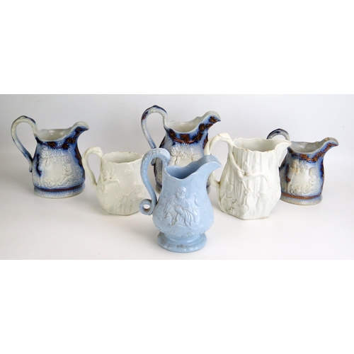 1542 - A set of three graduated moulded pottery jugs with putti decoration, together with three other mould... 