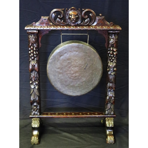 1606 - A Victorian bronze gong mounted in a heavily carved oak frame with lion mask and fruit decoration on... 