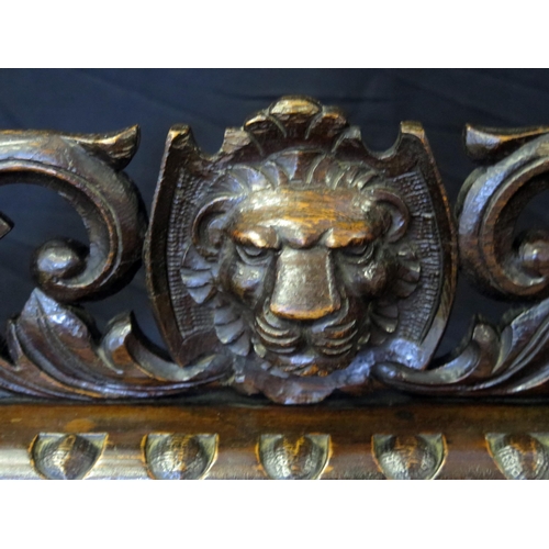 1606 - A Victorian bronze gong mounted in a heavily carved oak frame with lion mask and fruit decoration on... 