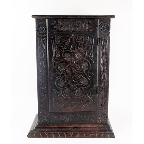 1622 - An antique oak table top cabinet, with plain top and associated carved panel door dated 1668, enclos... 