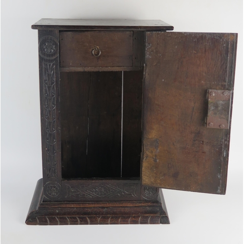 1622 - An antique oak table top cabinet, with plain top and associated carved panel door dated 1668, enclos... 