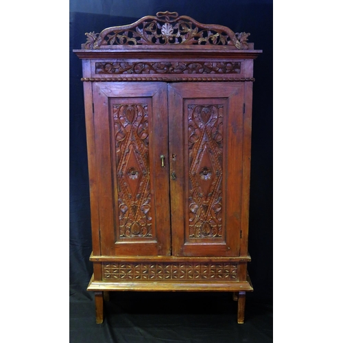 1626 - A continental walnut cabinet, with arched and carved foliate and scroll pediment, floral decorated f... 