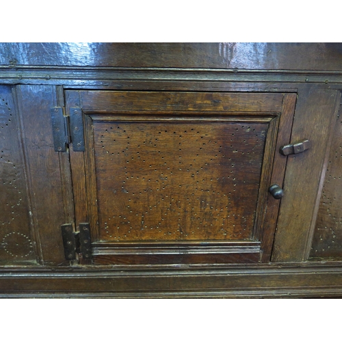 1638 - An 18th century oak dresser, with ledged top, with panelled cupboard door having pierced floral deco... 