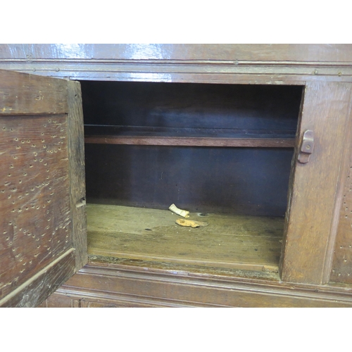 1638 - An 18th century oak dresser, with ledged top, with panelled cupboard door having pierced floral deco... 