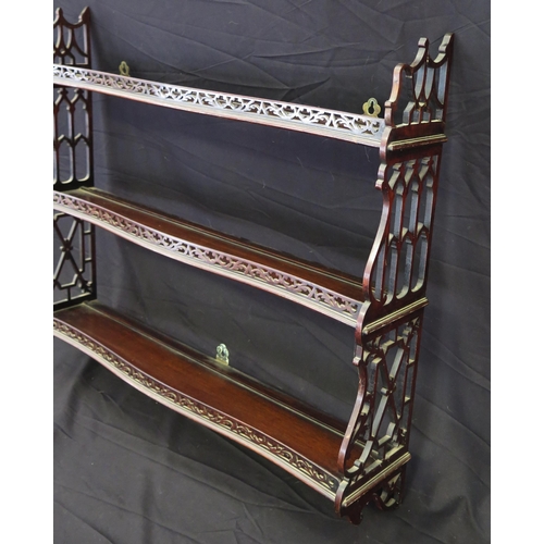 1647 - A set of three 19th century mahogany wall shelves of serpentine outline, with fret carved sides, 88c... 