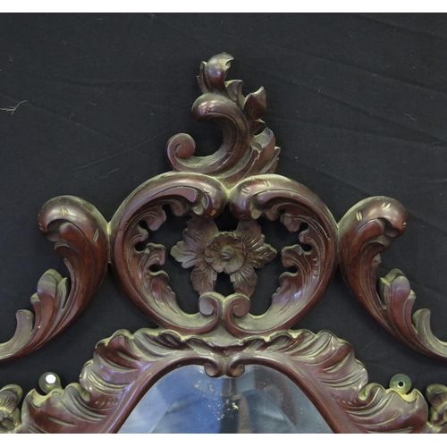 1654 - A Victorian mahogany framed wall mirror, of crested cartouche-shaped outline, with bevelled mirror p... 