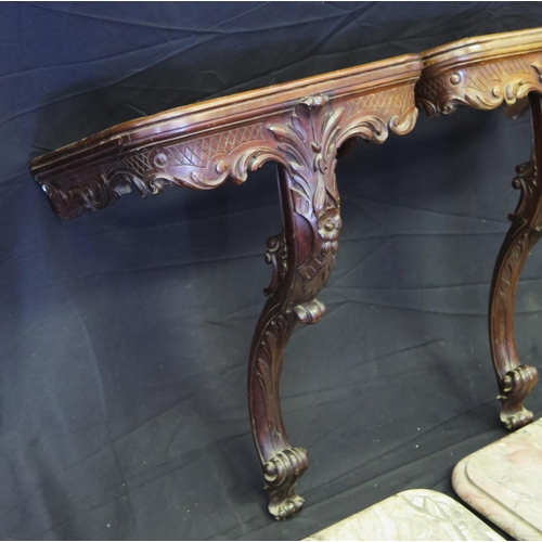 1656 - A pair of carved mahogany console tables, with rectangular marble tops, with foliate and scrolled fr... 