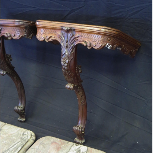 1656 - A pair of carved mahogany console tables, with rectangular marble tops, with foliate and scrolled fr... 